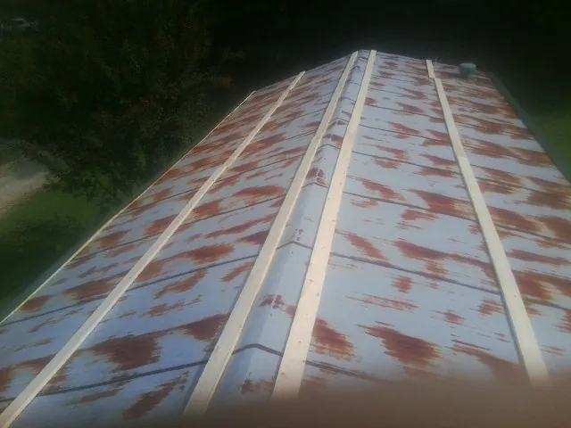 Rusted metal roof panels with new wood purlins before replacement — Storm Damage Roof Repair in Yorba Linda by Roofing Brothers