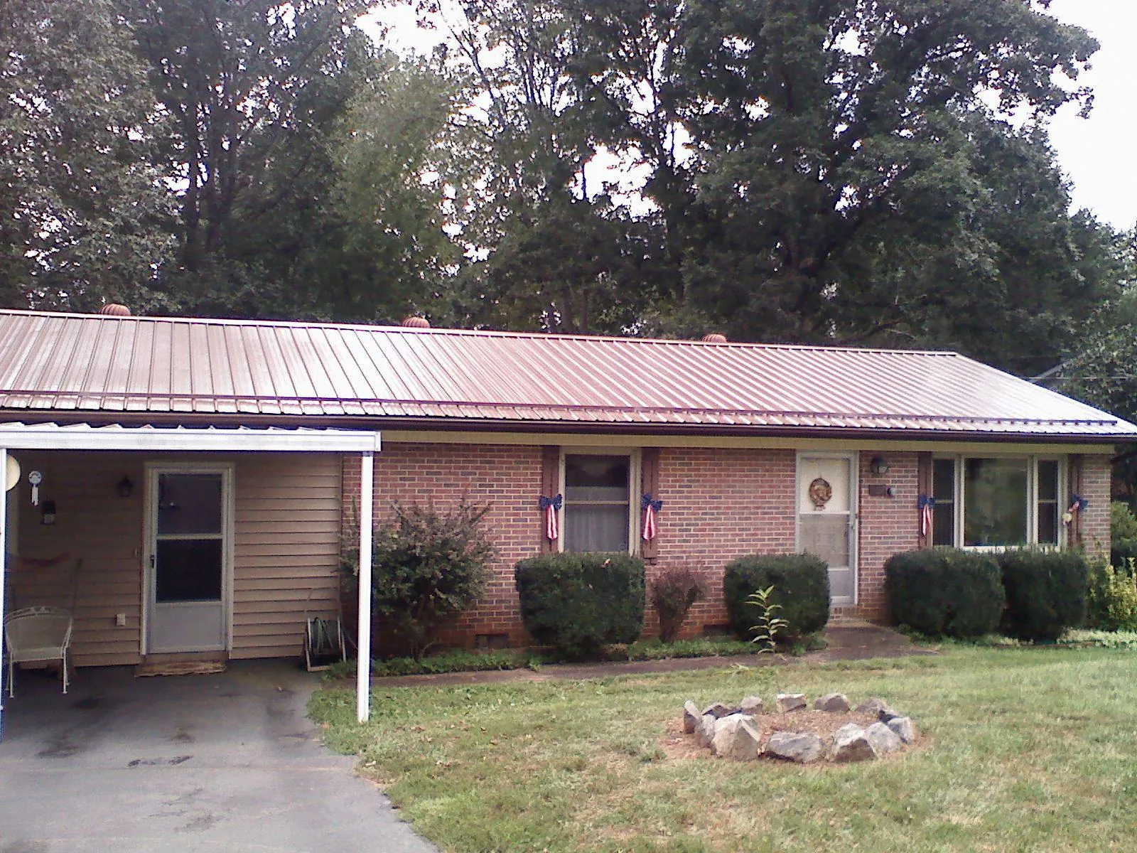 Bronze metal roof and carport on a brick ranch home — Roof Repair work by our crew in Yorba Linda